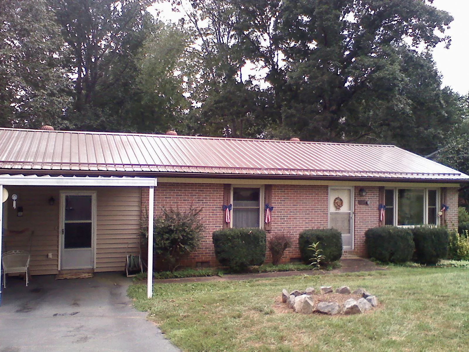 Bronze metal roof and carport on a brick ranch home — Roof Repair work by our crew in Sandy Hook